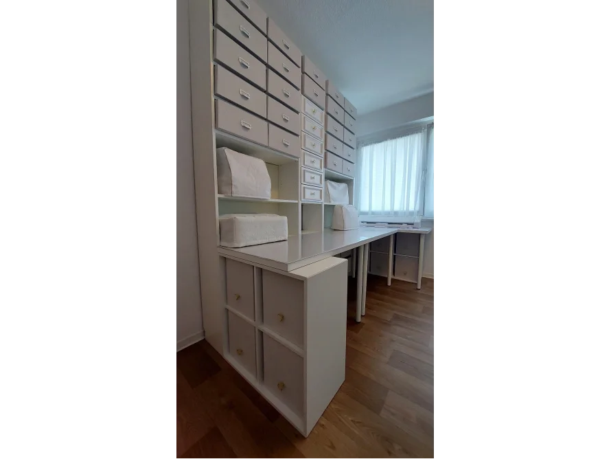 Ein weißer Nähtisch mit vielen Schubladen