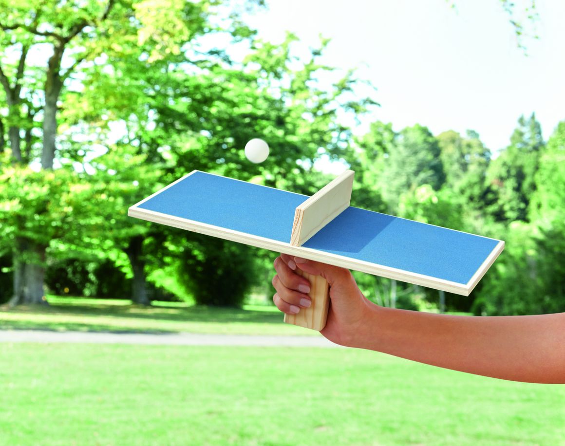 Eine Mini-Tischtennisplatte mit Ball in der Hand einer Person