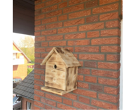 Vogelnistkasten aus Holz an Backsteinwand