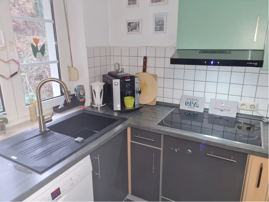 Küche mit schwarzen Arbeitsplatten und Spüle