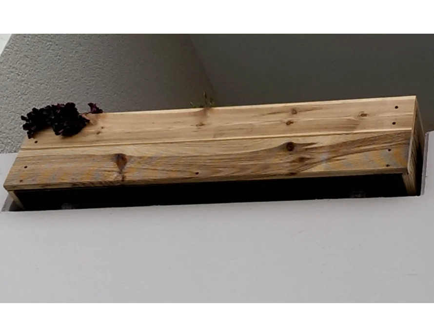 Hölzerner Blumenkasten an Hauswand