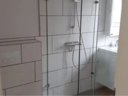 Geflieste Dusche mit Glastür