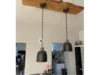 Zwei schwarze Hängelampen an Holzbalken