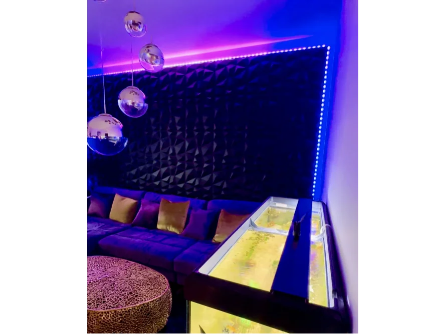 Modernes Wohnzimmer mit Aquarium und blauer Beleuchtung.