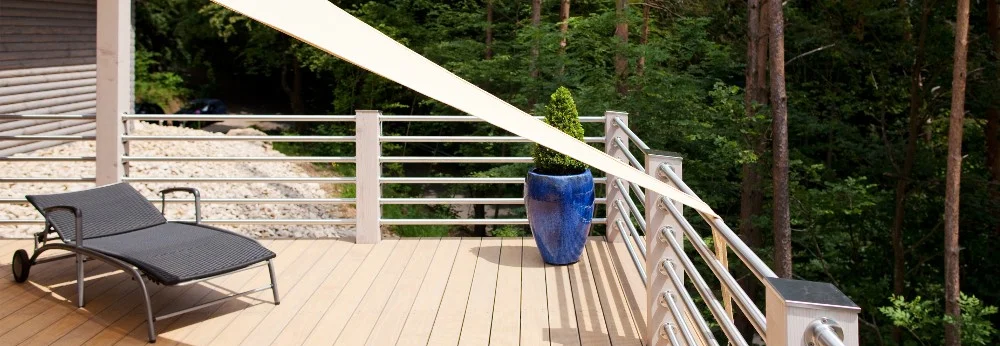 Leere Holzterrasse mit Sonnenliege und Sonnensegel