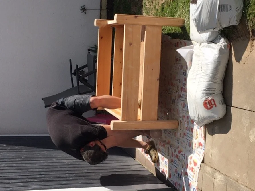 Person baut Holzgestell zusammen