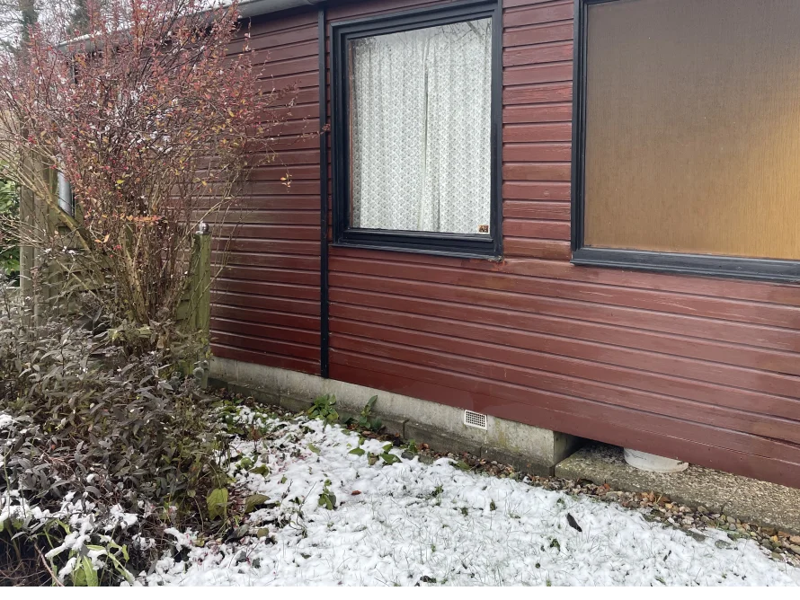 Gartenhauswand aus Holz mit Schnee bedeckt