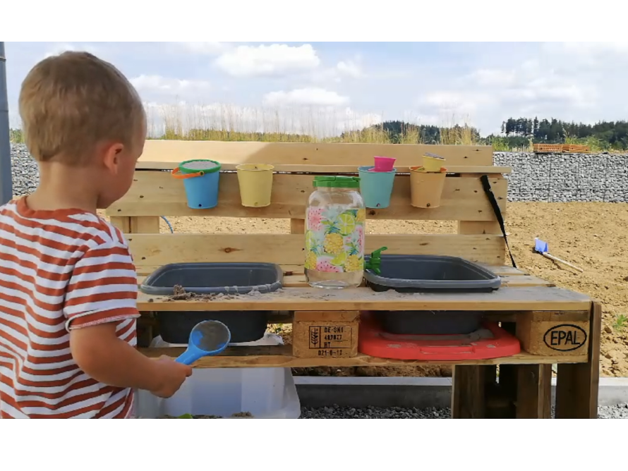 Kind mit Spielküche im Freien