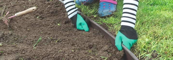 Person bringt eine Rasenkante an