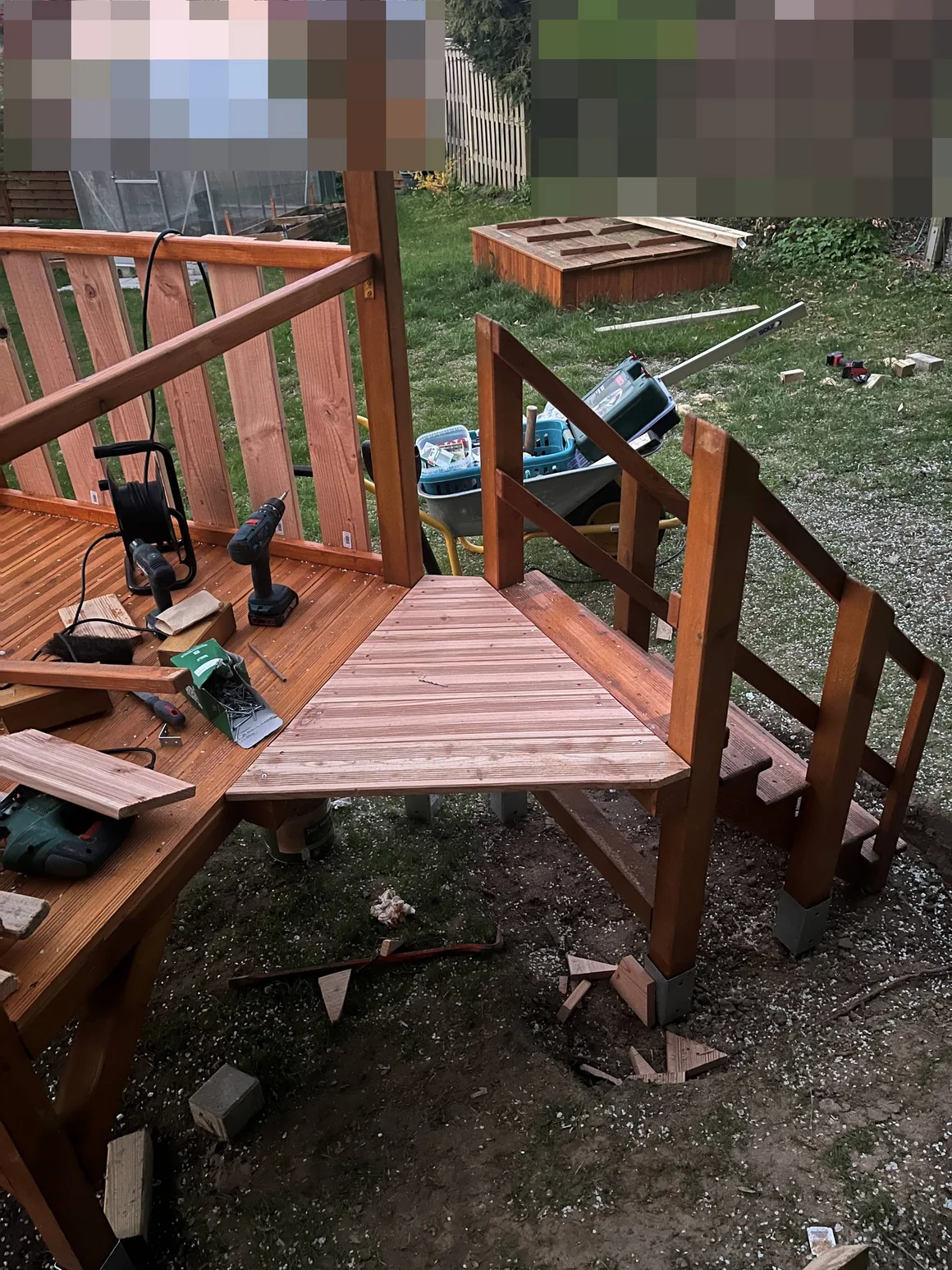 Aufbau eines Holzspielhauses mit Werkzeug im Garten.
