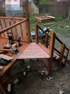 Aufbau eines Holzspielhauses mit Werkzeug im Garten.