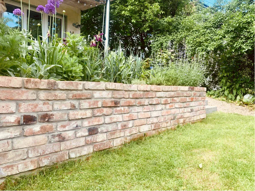 Gebogene Ziegelmauer im Garten