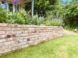 Gebogene Ziegelmauer im Garten