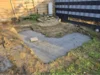 Ein frisch gegossenes Betonfundament im Garten.