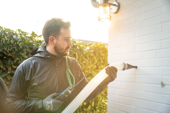 Ein VARM-Mitarbeiter führt eine Einblasdämmung durch