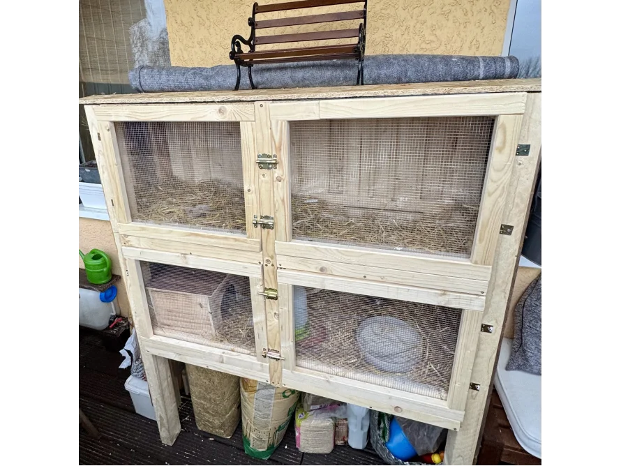 Holzstall mit Heu und Näpfen