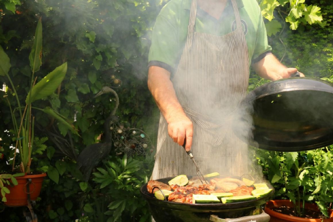 Mann grillt Fleisch