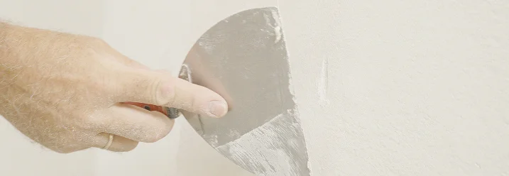 Hand spachtelt eine Wand