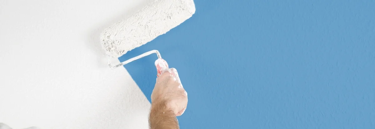 Person streicht Wand blau