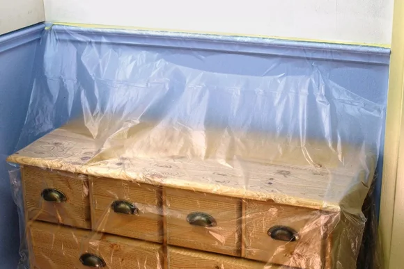 Abgedeckte Kommode mit Folie