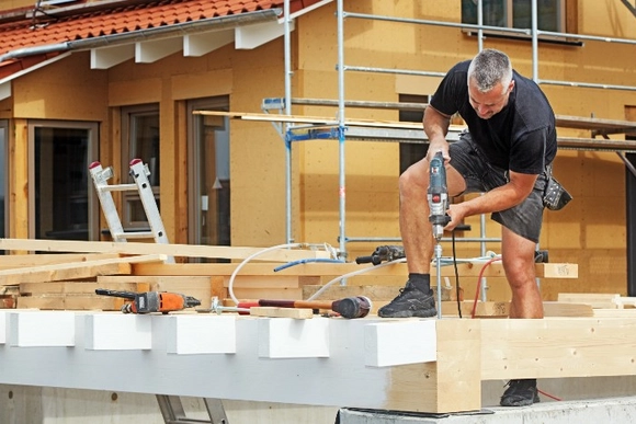Person baut ein Carport aus Holz