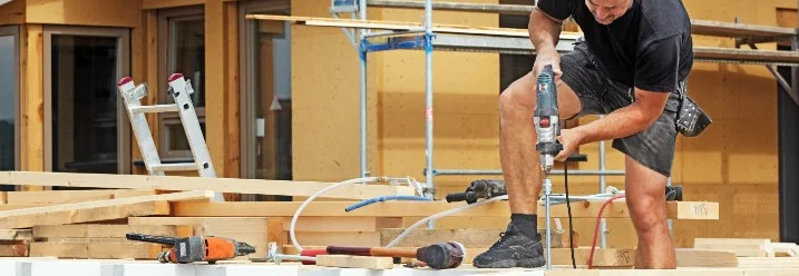 Person baut ein Carport aus Holz