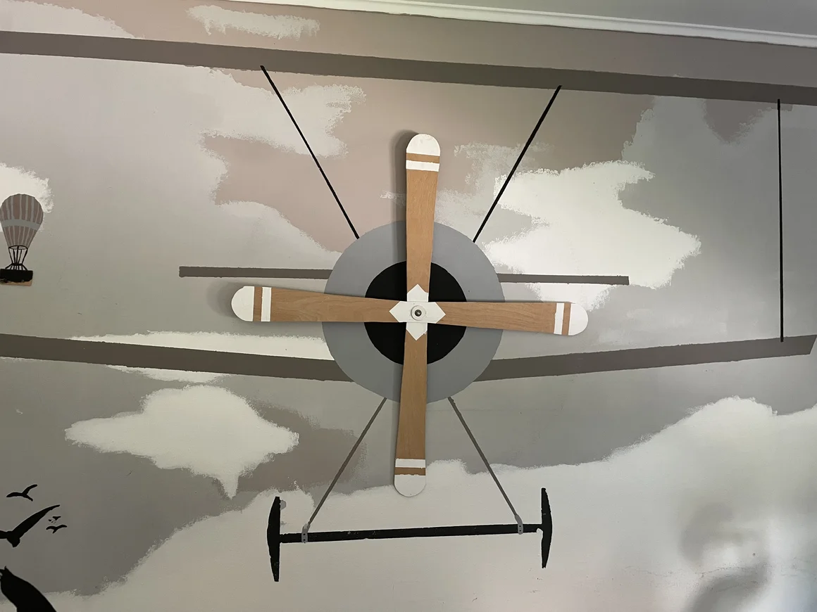 Ein Wandgemälde eines Flugzeugs mit einem hölzernen Propeller.