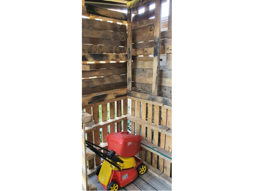 Gartenhaus aus Paletten mit Spielzeugrasenmäher