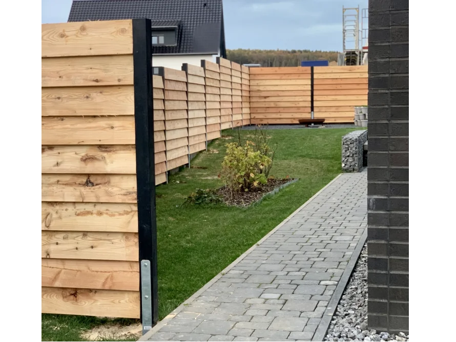 Moderner Holzzaun mit schwarzen Pfosten