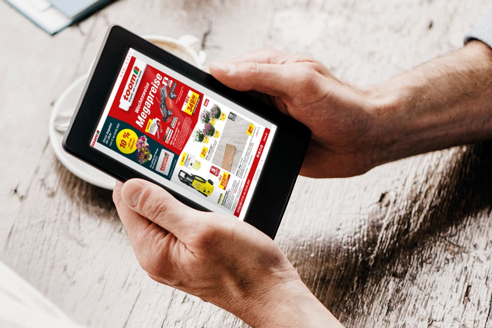Hände halten Tablet mit Prospekt