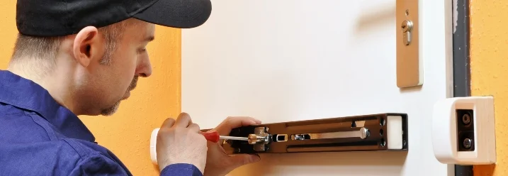 Person montiert Türschloss mit Schraubendreher