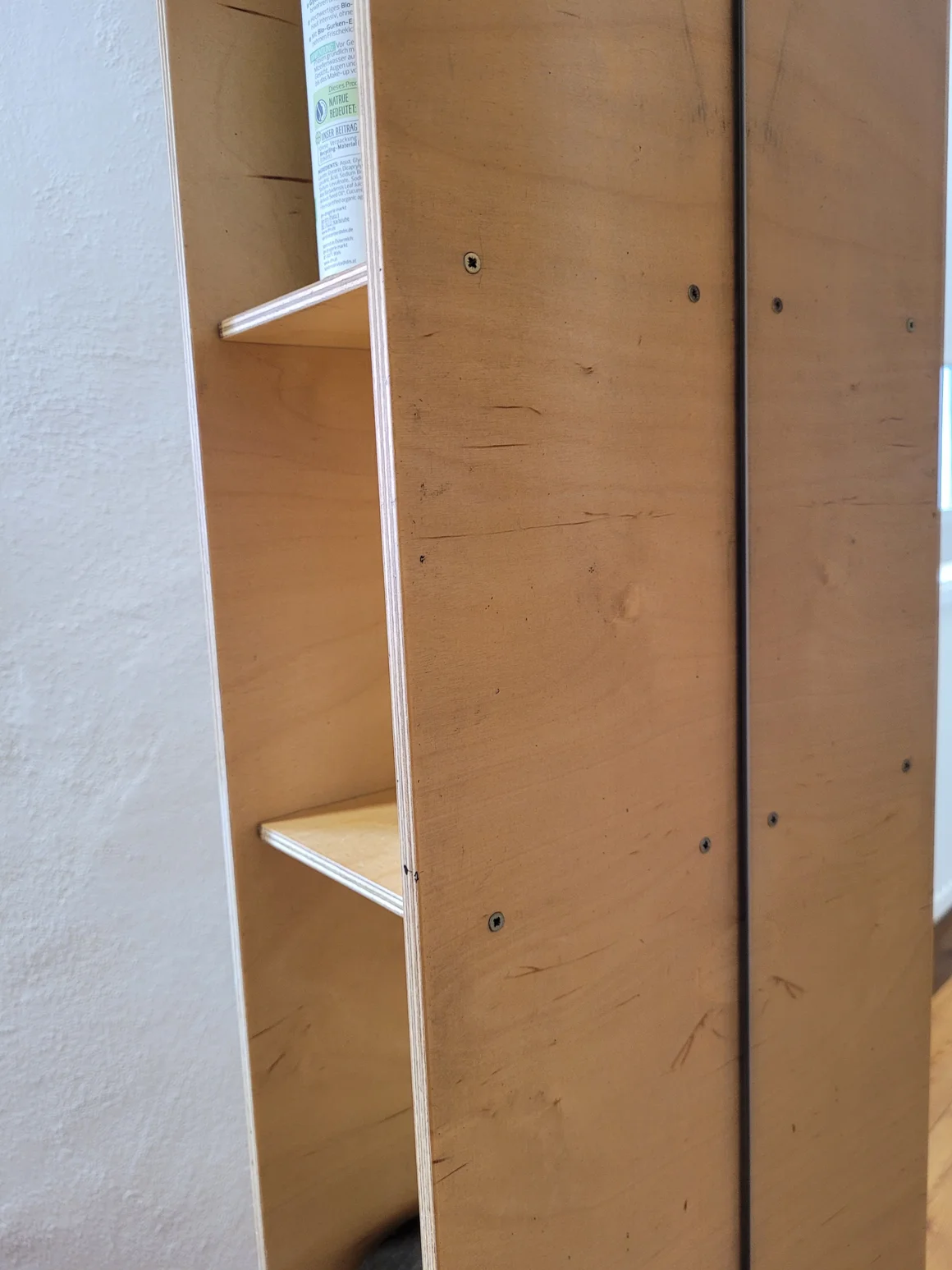 Untersicht eines montierten Holzregals mit Fächern aus hellem Holz.