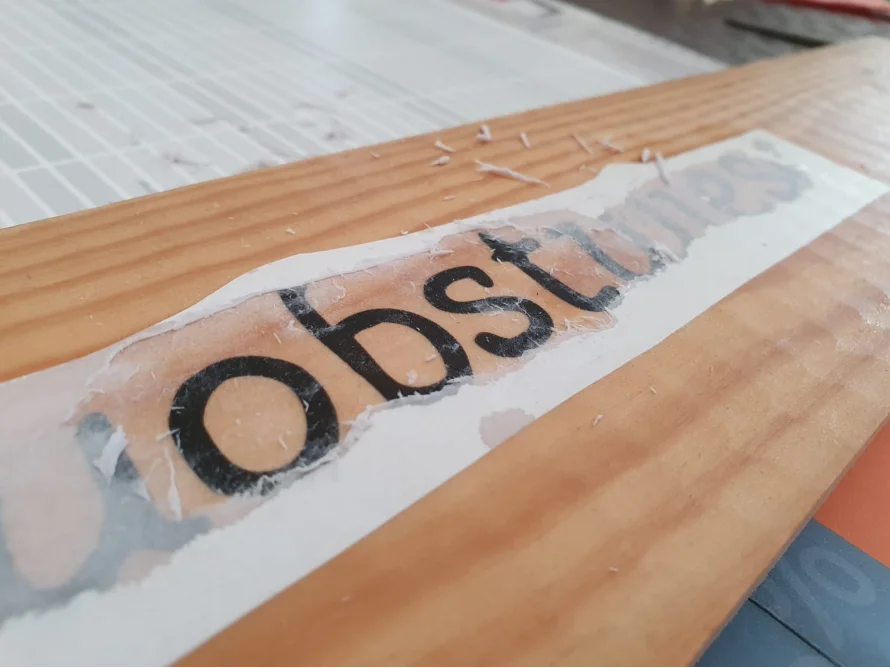 Buchstabenaufkleber auf Holzbrett