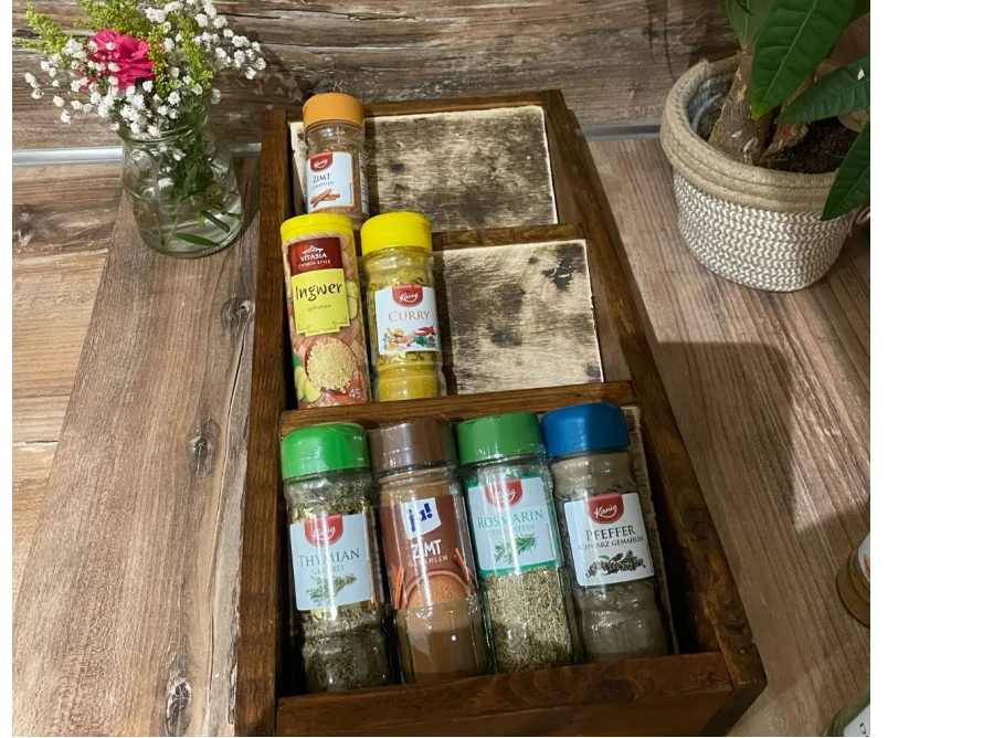 Ein hölzerner Gewürzständer mit verschiedenen Gewürzen.
