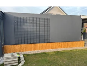 Holzgestell an grauer Hauswand