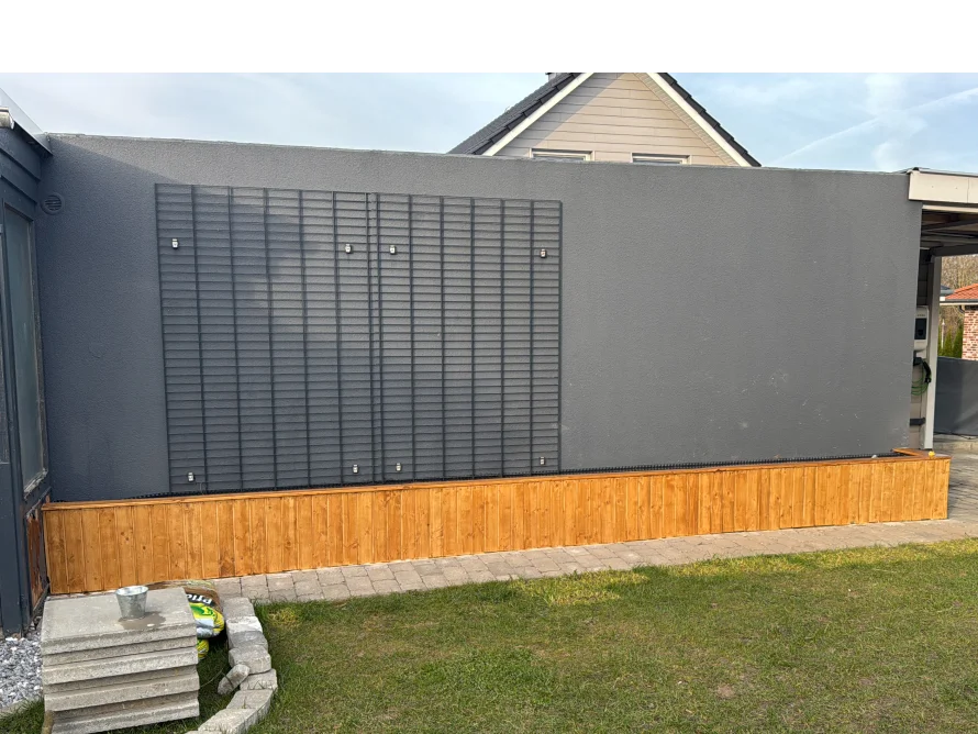 Holzgestell an grauer Hauswand