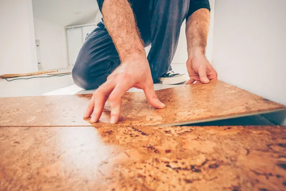 Person beim Verlegen von Korkboden