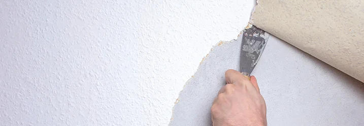 Hand entfernt Tapete mit Spachtel