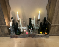 Glasflaschen und Kerzen auf Baumstamm