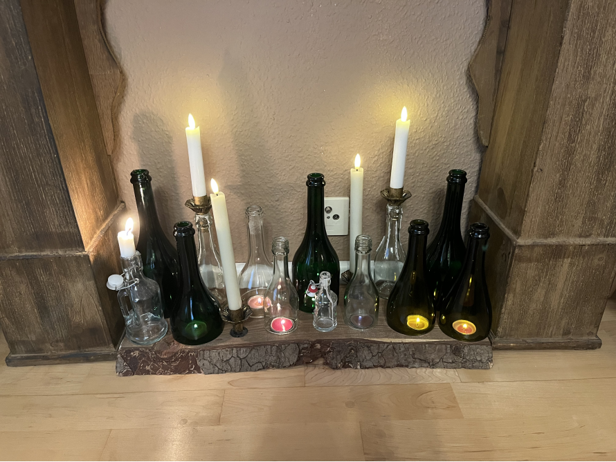 Glasflaschen und Kerzen auf Baumstamm