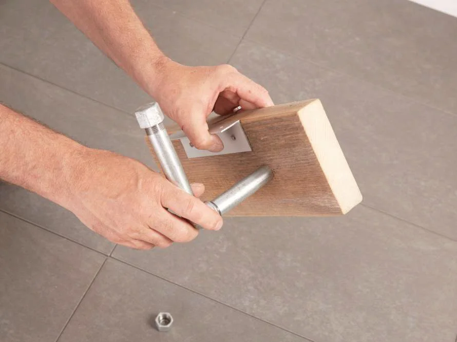 Rohr wird an Holzbrett montiert