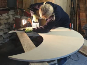 Person sägt eine Form aus Holz