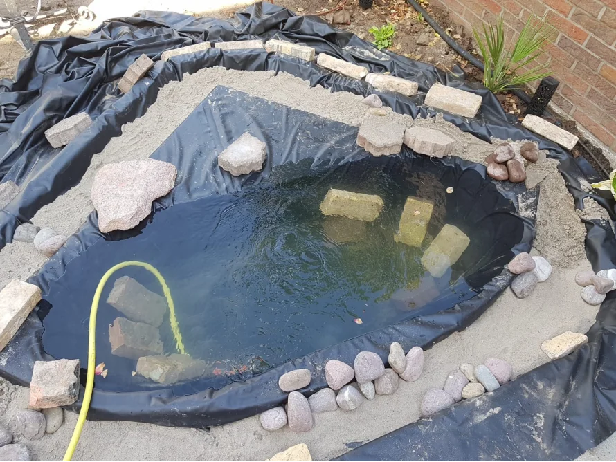 Teichfolie ausgelegt mit Steinen