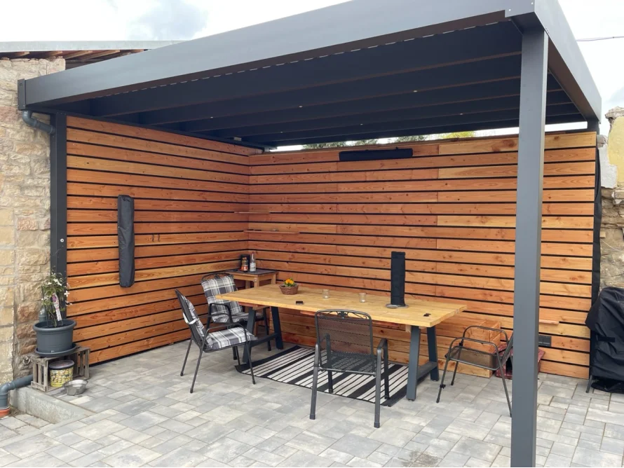 Überdachte Terrasse mit Essbereich.