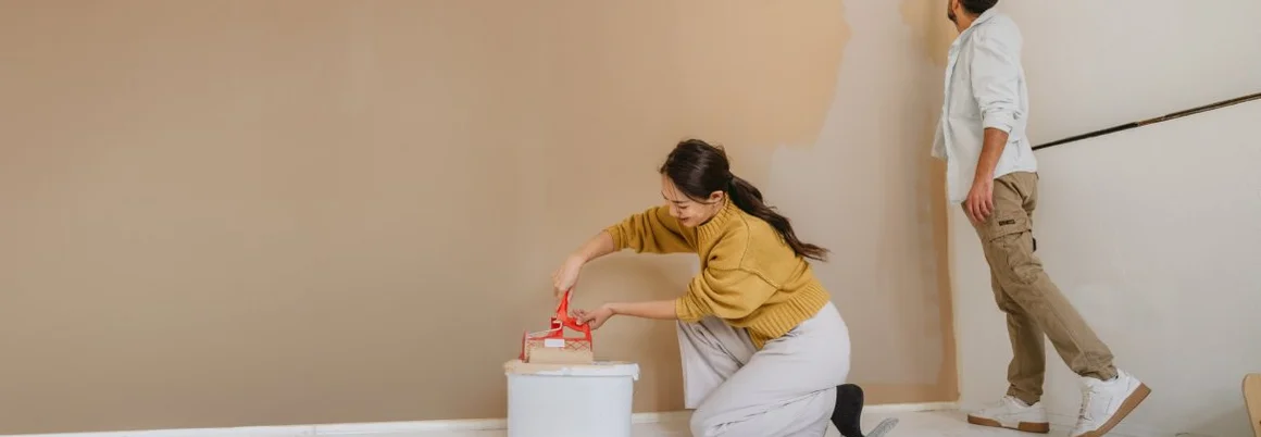 Paar, das während der Renovierung seines Hauses gemeinsam eine Wand streicht