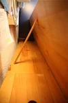Ein dünner Holzstab stützt eine hochgeklappte Holzplatte auf einem Schreibtisch.
