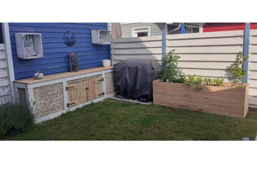 Gartenbereich mit Hochbeet und Anrichte