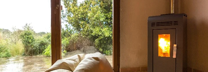 Gemütlicher Raum mit Kaminofen und Blick nach draußen