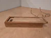 Eine kleine Box aus Holz liegt neben einer Brille.