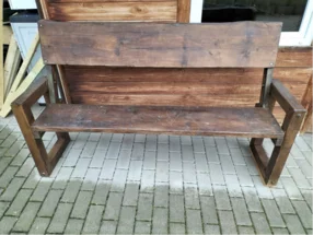 Rustikale Holzbank auf einem gepflasterten Weg